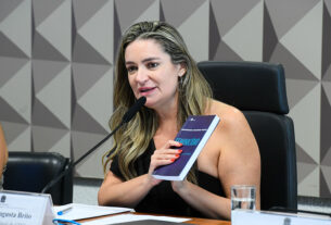 À mesa, presidente eventual da CDH, senadora Augusta Brito (PT-CE), exibe livro "Feminicídio - Mapeamento, Prevenção e Tecnologia".