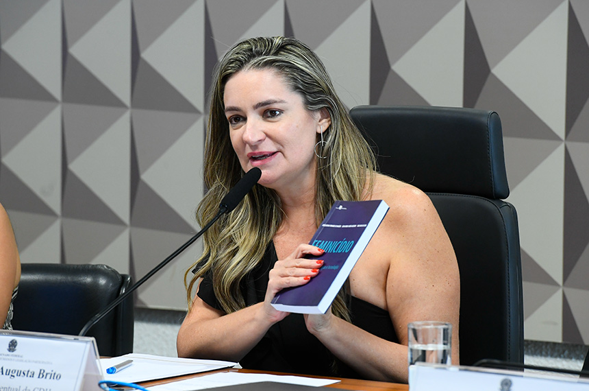 À mesa, presidente eventual da CDH, senadora Augusta Brito (PT-CE), exibe livro "Feminicídio - Mapeamento, Prevenção e Tecnologia".