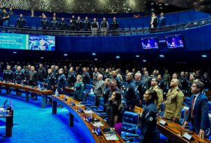 Em posição de respeito, convidados e parlamentares acompanham execução do Hino Nacional.