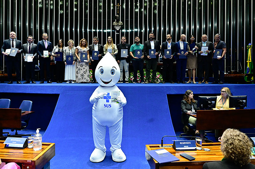 Zé Gotinha posa para foto com parlamentares e convidados.